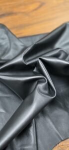 Black leather fabric draped over a wooden surface