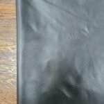 Black leather material with a wooden background
