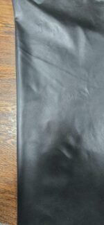 Black leather material with a wooden background