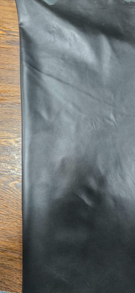 Black leather material with a wooden background