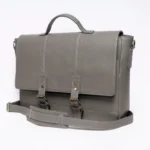 Gray leather satchel with white stitching and brass buckles