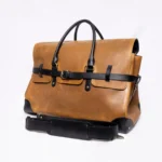 Tan leather duffel bag with black accents and strap