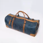 Blue and tan leather duffel bag with double handles and strap accents