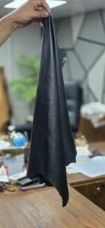 Black leather material held in hand, draped