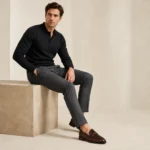Man in black long-sleeve polo shirt and gray trousers wearing brown leather loafers