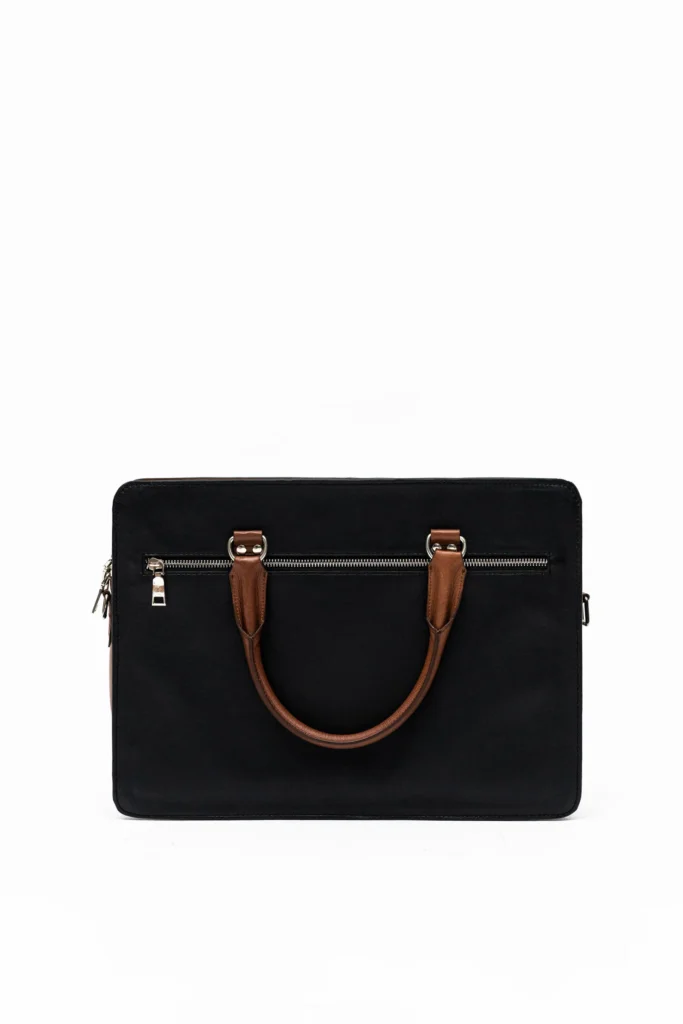 Black laptop bag with brown leather handle and silver hardware