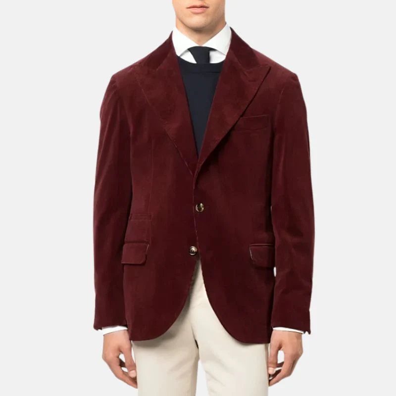 Man wearing a burgundy corduroy blazer over a navy sweater and white shirt, paired with cream trousers